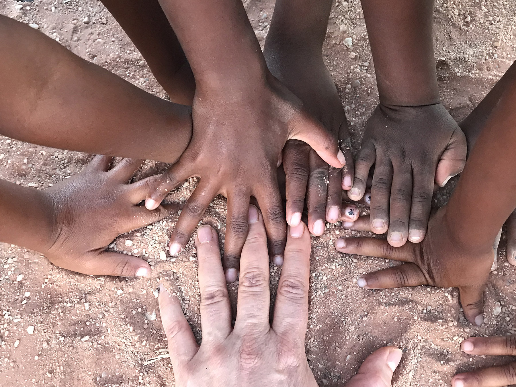Miriam Delicado holding hands with children in a moment of connection and care